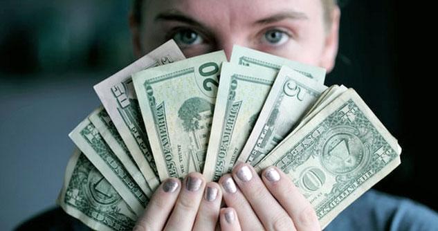 Woman showing cash fanned out in 50s, 20s, 5s and 1s.