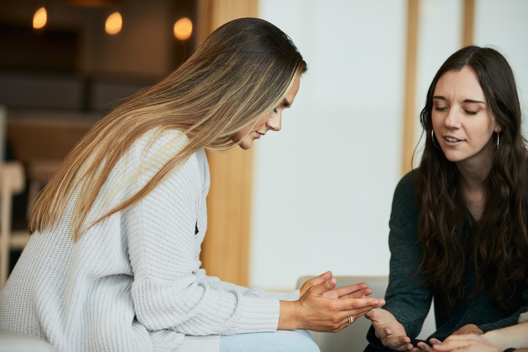 Two women pray together