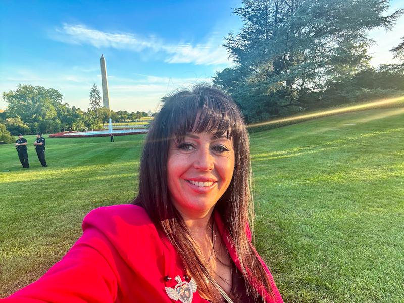 Debra takes a selfie with the Washington Monument on her trip to D.C. at the invitation of President Biden Sept 2024.